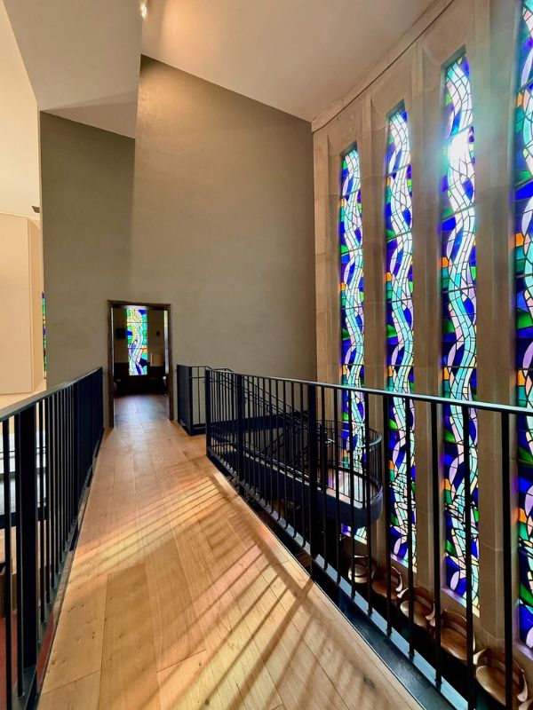 Hardwood flooring hallway with stained glass windows in historic church renovation at Church of Pickleball Chicago IL